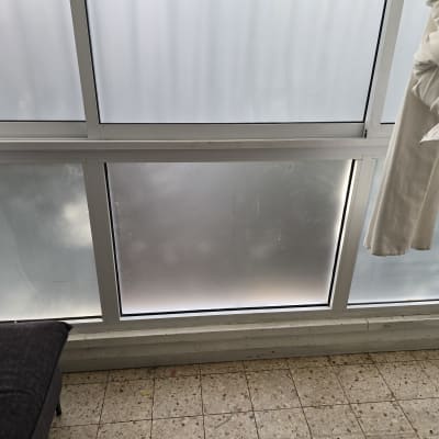 חלון זכוכית עם וילון לבן בצד ימין