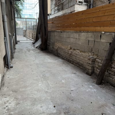 גדר עץ לאורך שביל בטון ליד בניין