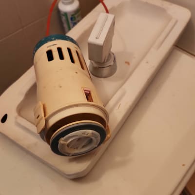 חלקי ברז מפורקים על כיור בחדר אמבטיה