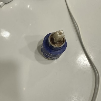 חלק פלסטיק כחול על משטח לבן, ייתכן קשור לאינסטלציה