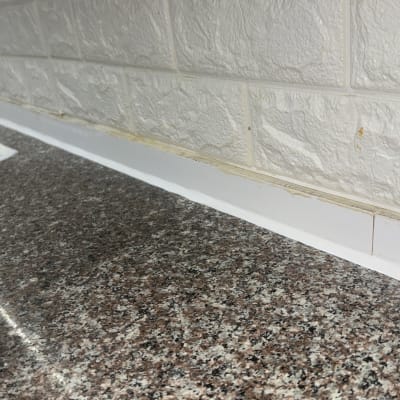 כיור מטבח עם ברז, משטח שיש וקיר אריחים