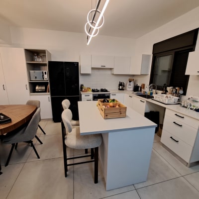 מטבח מאורגן עם אי מרכזי, שולחן עגול וכיסאות.