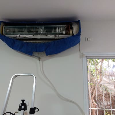 מזגן עם כיסוי כחול לניקוי, צינור מחובר