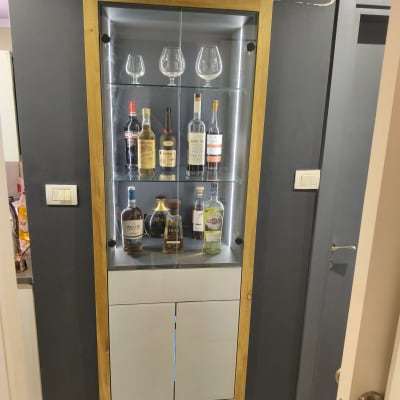 ארון תצוגה מעץ עם בקבוקי משקאות וכוסות