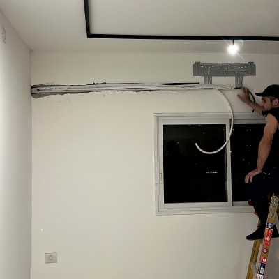 התקנת מזגן על קיר, אדם על סולם