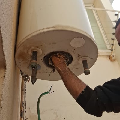 דוד שמש מותקן על קיר עם יד מתקין