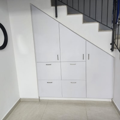 ארון לבן מתחת למדרגות עם ידיות מתכת