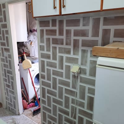 קיר עם אריחים חדשים במטבח במהלך שיפוץ