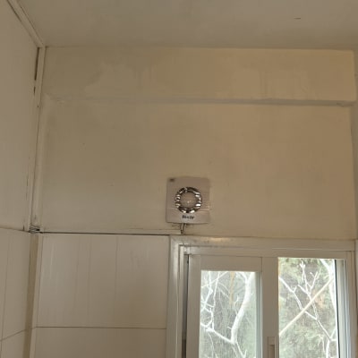 קיר עם סימני רטיבות ליד חלון מאוורר