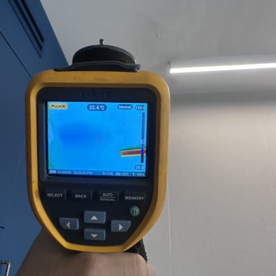 מד חום אינפרא אדום מציג טמפרטורה על קיר