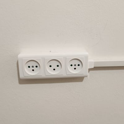 שלוש שקעים חשמליים מותקנים על קיר לבן