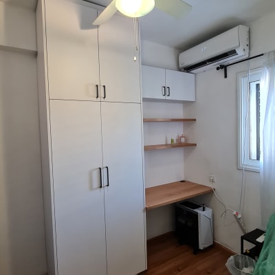 ארון לבן עם מדפים ושולחן עץ בחדר