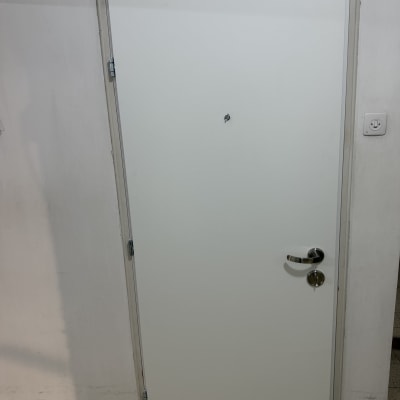 דלת לבנה עם ידית מתכת וקיר לבן