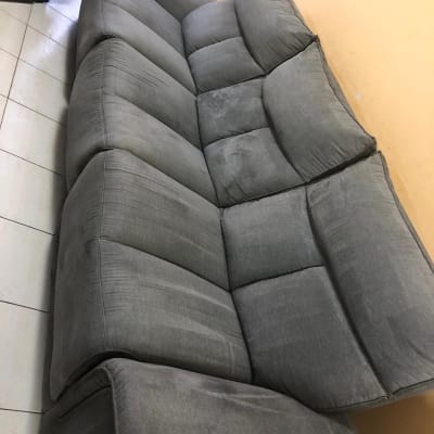 ספה אפורה עם כתמים קלים על רצפת קרמיקה