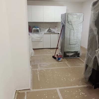 חדר עם רצפה מכוסה בנייר, דלי צבע ומטאטא