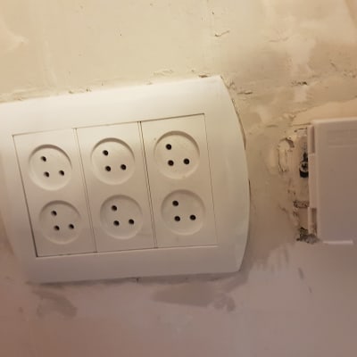 שקע חשמל עם שישה חיבורים על קיר