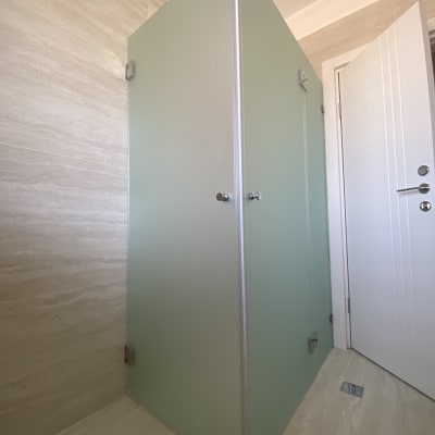 תא מקלחת עם דלת זכוכית ירוקה וידיות מתכת