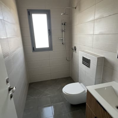 חדר אמבטיה נקי עם מקלחת, כיור ואסלה