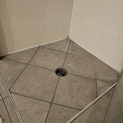 ריצוף אריחים עם חור לניקוז במקלחת