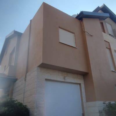 בית עם תריסים סגורים וחיפוי אבן