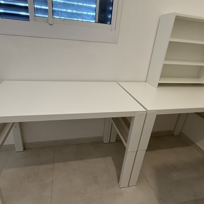 שולחנות לבנים עם מדפים בחדר ריק