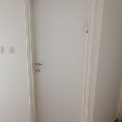 דלת לבנה עם ידית מתכת ומנעול