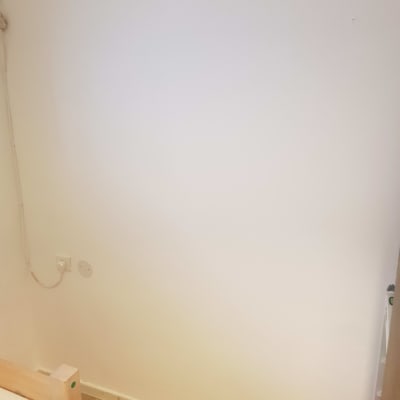 קיר לבן עם שקע חשמל וכבל חשמל