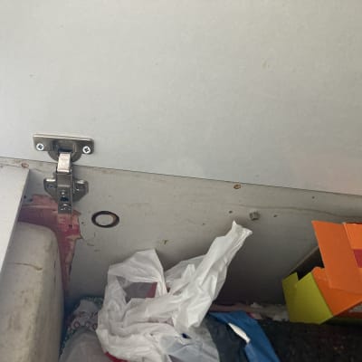 ציר מתכת מותקן על דלת ארון עץ