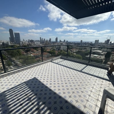 מרפסת עם נוף עירוני וכיסא פלסטיק