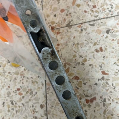 מנעול מתכת עם חורים וברגים, מוחזק ביד