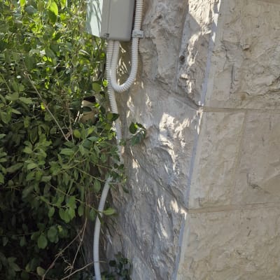 תיבת חשמל על קיר אבן עם צינורות חשמל