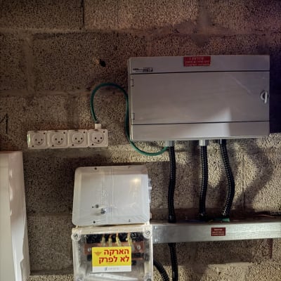 לוח חשמל עם שקעים וכבלים מותקנים על קיר בטון