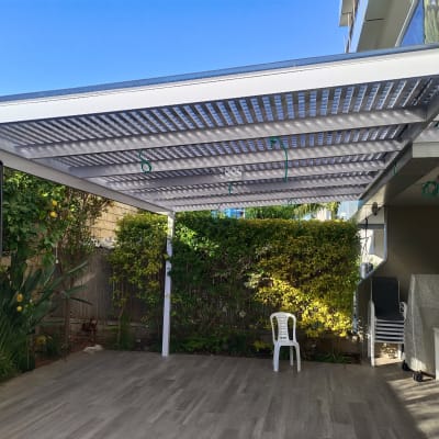פרגולה מאלומיניום עם קורות אופקיות בחצר