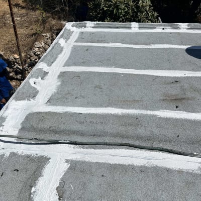 גג עם איטום לבן על משטח אפור