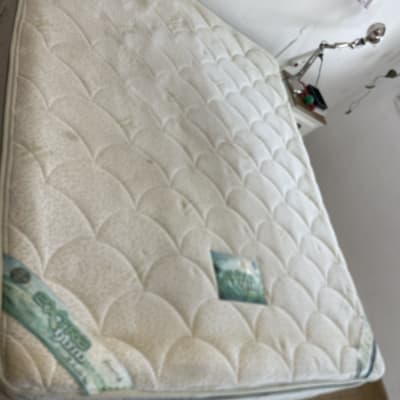 מזרן על מיטה בחדר שינה עם מנורת קריאה