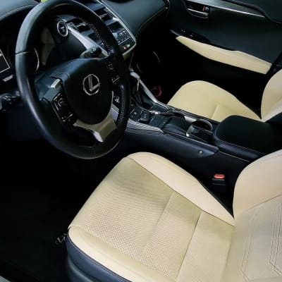 פנים רכב עם מושבים בהירים והגה שחור