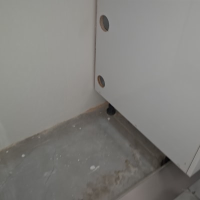 ארון עם חורים לצנרת על רצפת בטון