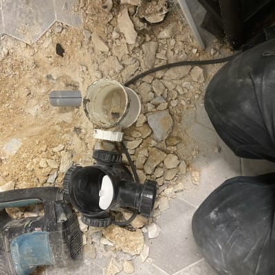 כלי עבודה וצינור על רצפה עם אבנים