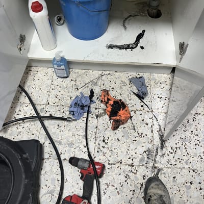 כלי עבודה וצינור מתחת לכיור עם לכלוך