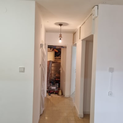 מסדרון עם קירות צבועים בלבן ונורה תלויה