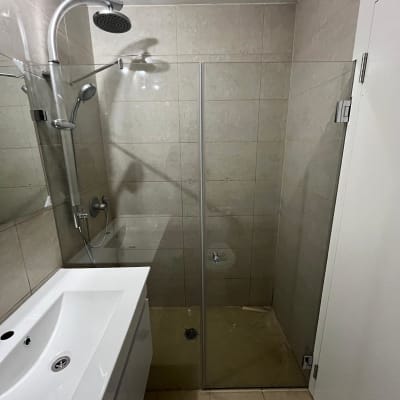 מקלחת עם ראש גשם ודלת זכוכית שקופה