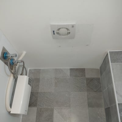 מאוורר תקרה ומחמם מים חשמלי בחדר אמבטיה
