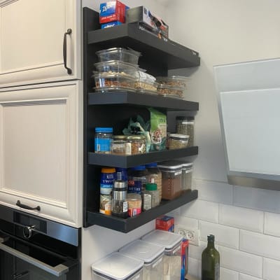 מדפים שחורים עם קופסאות תבלינים ומזון במטבח