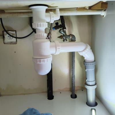 צנרת מתחת לכיור עם חיבורים וברזים