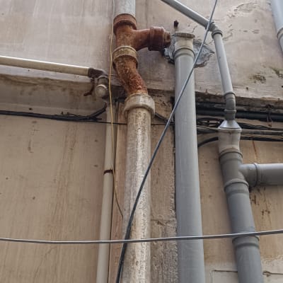 צינורות מתכת ופלסטיק מחוברים לקיר חיצוני