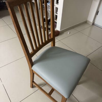 כיסא עץ עם ריפוד אפור על רצפה מרוצפת