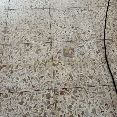 רצפת טרצו עם כתמים וחוט חשמל שחור