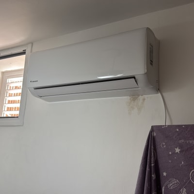 מזגן מותקן על קיר ליד חלון פתוח