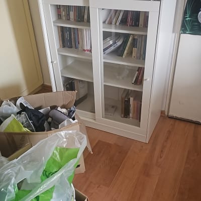 ארון ספרים עם קופסאות ופריטים על הרצפה