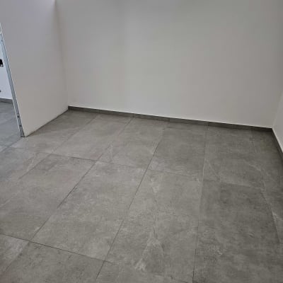 רצפה נקייה עם אריחים אפורים בחדר ריק